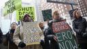 Activists hold signs calling for the closure of the Berks County migrant detention center during a Philadelphia rally.