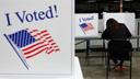 Polling place tables topped with privacy screens reading "I Voted!" 