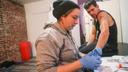 Volunteer Jen Shinefeld cleans a wound on the arm of Nick Gallagher at an outreach organization based in Philadelphia.