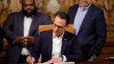 Gov. Josh Shapiro signs the final pieces of the 2023 Pennsylvania budget in the Capitol.