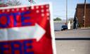 A sign urging people to "vote here" on Election Day 2022.