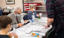 Volunteers open and sort mail-in ballots in Erie while poll watchers observe.