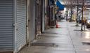 A man standing on the sidewalk on 52nd Street is surrounded by local business’s that are closed due to the coronavirus outbreak on Saturday, March, 28, 2020.