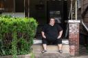 Mike Ramsey sits on the front porch of his house.