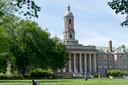 People walk across Old Main lawn on the Penn State campus.