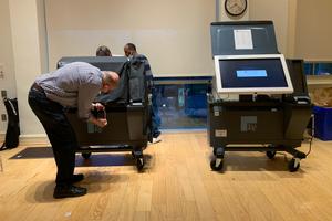 An election worker in Philadelphia, Pennsylvania examines an ExpressVoteXL voting machine during the 2022 primary.