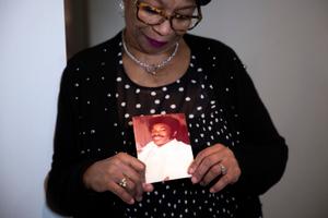 Mary Buffaloe holds a picture of her brother Raymond Caliman.