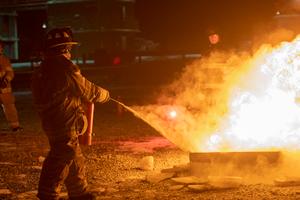 A firefighter puts out a fire during a training class.