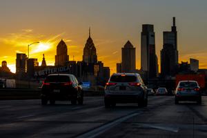 The sun sets behind City Hall and the Philadelphia skyline Dec. 3, 2021, photographed on southbound Interstate I-95, just north of Center City.