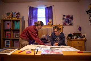 Lauren Zak, a direct support professional for Emmaus Community of Pittsburgh, helps Emmaus resident Diane change her sheets.